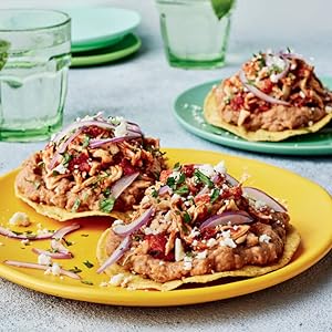 tostadas topped with refried beans &amp; shredded chicken on colorful plates