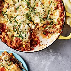 photo of a lasagna in a round dish with a slice taken out