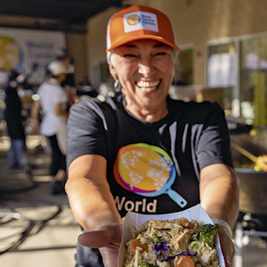 smiling WCK Volunteer sharing food.