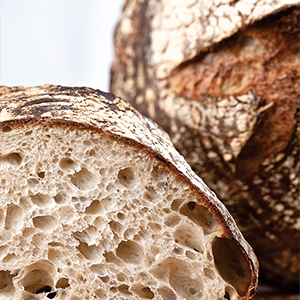 Photograph of inside of baked bread loaf with crispy crust and soft crumb