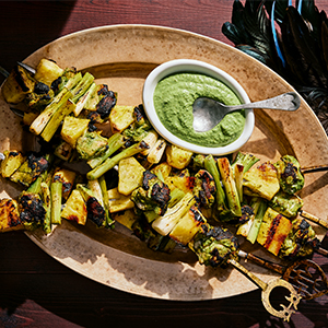 A photo of the recipe Bad Aim Chicken on a plate next to a bowl of green sauce