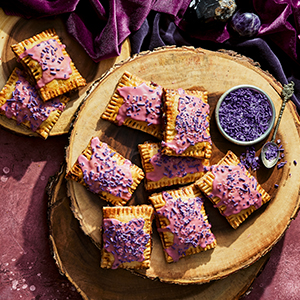 A photo of the recipe Scanlan's Hand Pies on a plate next to a bowl of purple sprinkles