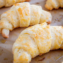 Golden brown, flaky croissants on a baking sheet