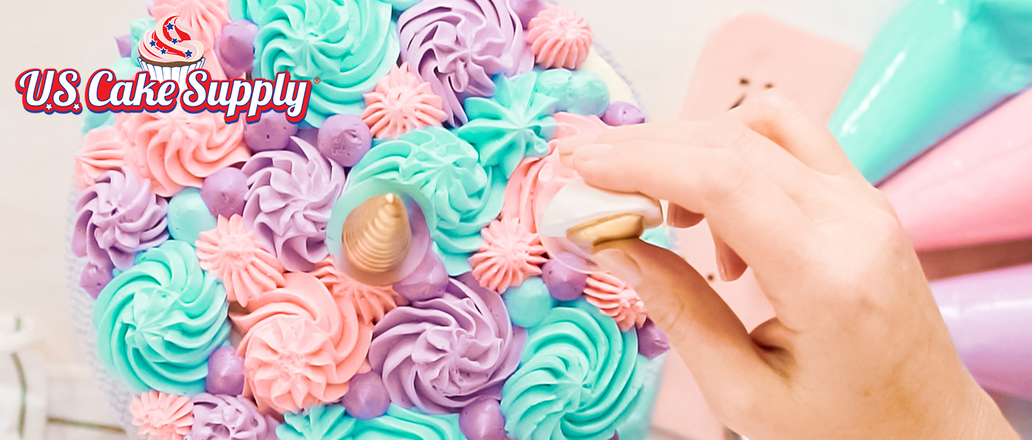 cake being decorated in colorful frosting