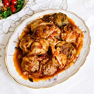 Stuffed cabbage red sauce placed in a decorative, oval serving dish.