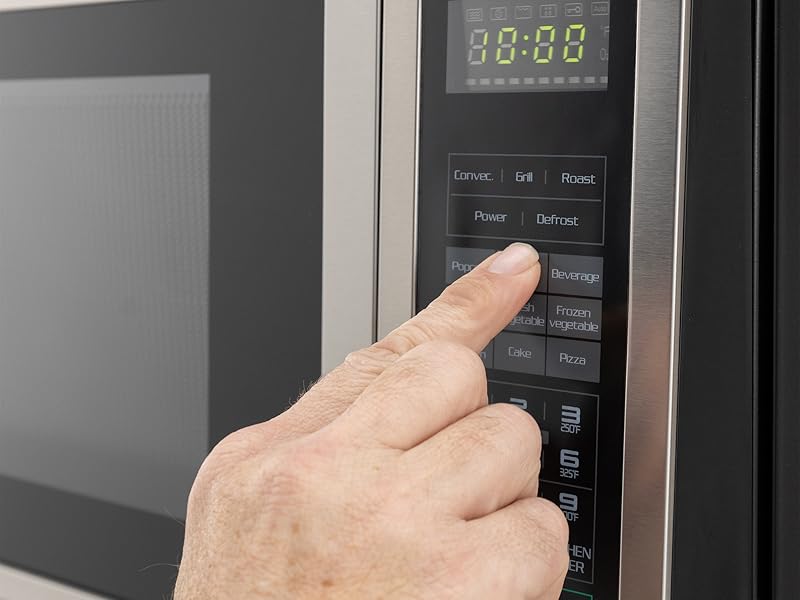 Someone using the touch pad on a microwave. 