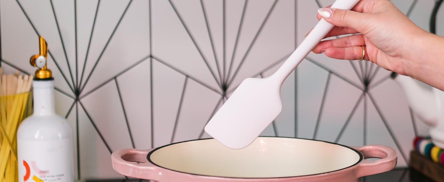 Silicone spatula using to cook in a pink pot on the stovetop