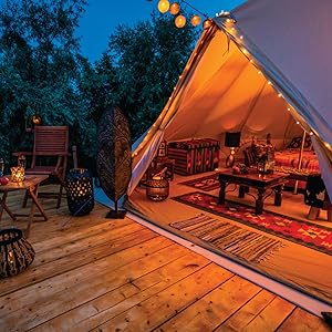 A glamping style tent with furniture. 