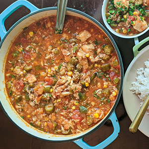 Overhead view of catfish stew in a light blue dutch oven pot